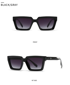 Detail view of black square sunglasses featuring silver arrow metal trim and grey lenses