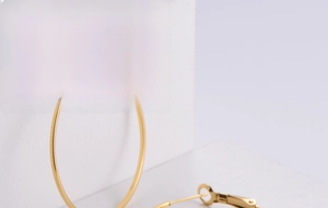 Detail view of large 18k gold plated hoop earrings with smooth polished metallic finish