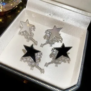 Star-shaped tassel earrings set with shell inlay and cubic zirconia in a jewelry box