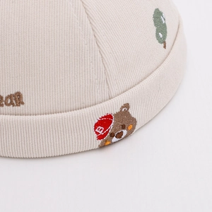 Cute cream corduroy baby miki hat with embroidered bear and tree designs