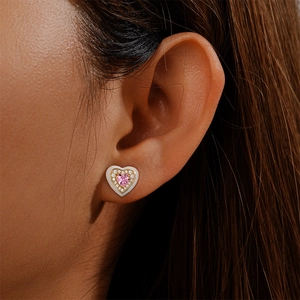 Close-up of model wearing 925 silver heart stud with pink crystal and white enamel