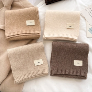 Folded knitted scarves in camel, beige, oat and dark brown with soft wool texture