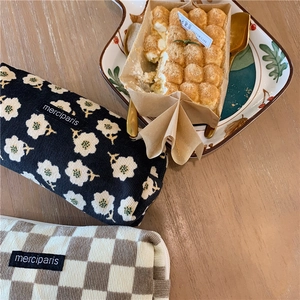 Corduroy floral and plaid pouches on a wooden table with elegant dessert settings