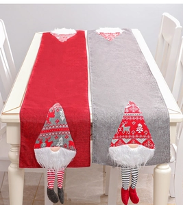Detail of Christmas table runner with red and grey 3D gnome dolls and striped long legs