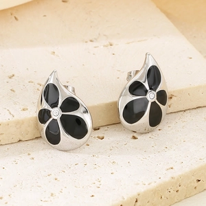 Macro view of waterdrop earrings with black enamel flower and center diamond detail