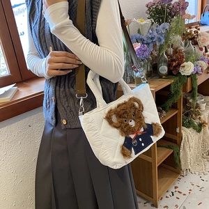 Quilted white kids handbag featuring a cute brown teddy bear with adjustable strap