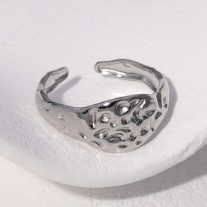 Macro detail of silver hammered texture on an adjustable stainless steel open ring