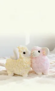 Close-up of fluffy cream and pink plush sheep toys with soft curly wool texture