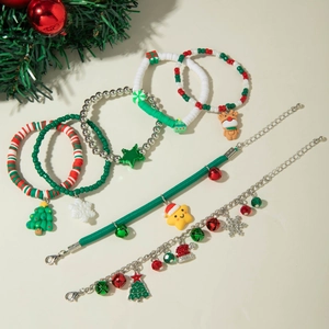 Close-up of festive Christmas bracelets with Santa Claus and reindeer charms on red cord