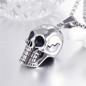 Detailed macro view of silver stainless steel skull pendant with textured cracks