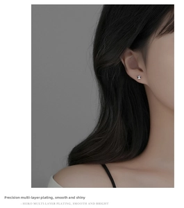 Nahaufnahme eines Models mit kleinen S999 Silber Panda-Ohrsteckern mit Schwarz-Weiß-Emaille