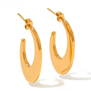 Detail of gold geometric C-shaped oval hoop earrings with flat mirror polished surface
