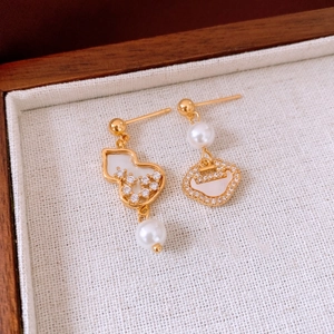 Macro view of gold-plated calabash and Ruyi lock earrings with pearls and crystals