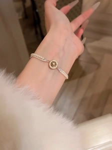 French retro double-layer gold pearl bracelet with vintage relief pendant worn on wrist