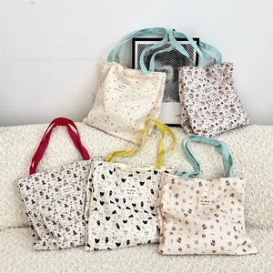 Detail of cute cat printed canvas tote bags featuring waffle texture on soft sofa