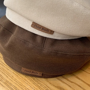 Classic wool felt beret hats in cream and dark brown featuring a handmade leather label