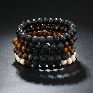 Detailed view of stacked vintage wooden and black volcanic stone beaded bracelets