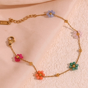 Close-up of golden stainless steel chain with five colorful beaded daisy flowers and K18 tag