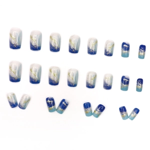 Blue marble gradient press-on nails with gold foil accents and wavy patterns on white background