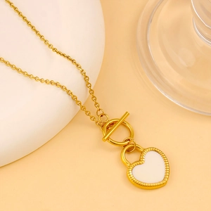 Détail du collier en acier doré 18K avec pendentif cœur en émail blanc et fermoir en T