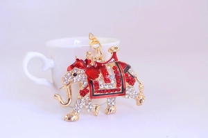 Detailed close-up of a golden elephant keychain with sparkling red and white rhinestones