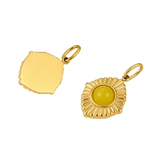 Macro view of gold stainless steel sunburst pendant with center yellow natural stone