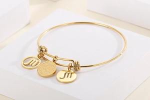 Detailed macro shot of a gold-plated stainless steel Scorpio charm bracelet on a white block