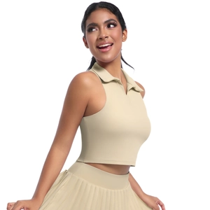 Détail du haut polo sans manches kaki clair et de la jupe plissée en tissu de sport extensible