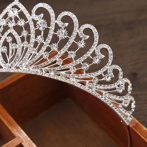 Detailed view of silver crown with rhinestones on vintage wooden box for wedding