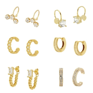Minimalistisches Set aus goldenen Zirkonia-Ohrringen und Earcuffs auf weißem Hintergrund