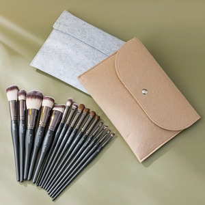 Macro shot of 15 piece black makeup brush set with silver ferrules and grey felt bags