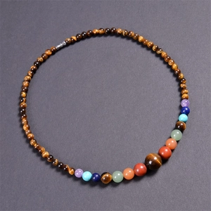 Macro shot of 6mm tiger eye beads and colorful chakra gemstones on a beaded necklace