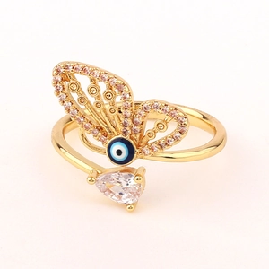 Macro detail of gold butterfly ring with blue evil eye and sparkling pear-cut crystals