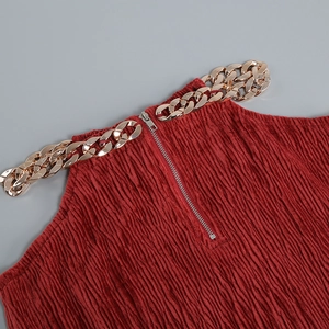Detail of dark red halter top with thick gold chain straps and vertical pleated fabric