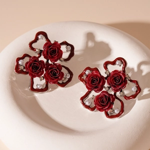 Detail of vintage red rose earrings with white pearls and sparkling rhinestones
