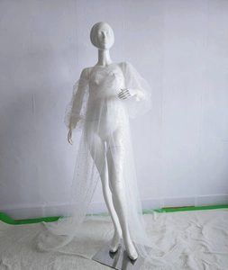Detail of white mesh maternity gown featuring delicate pearl beading and lantern sleeves
