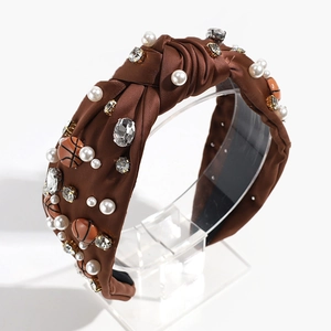 Detail view of brown knotted headband with faux pearls, rhinestones and mini basketballs
