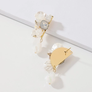 Detail of floral crystal earrings with white shell petals and a teardrop pearl drop
