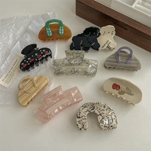 Set of nine stylish acetate hair claws featuring floral and dog designs in neutral tones