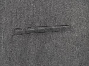 Macro shot of precise stitching on deep gray casual trousers with flat weave texture