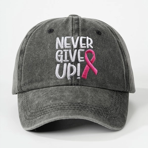 Detailed view of NEVER GIVE UP embroidery and pink ribbon on washed cotton baseball cap