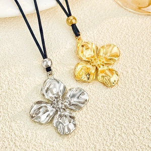 Colliers floraux exagérés en finitions or et argent avec cordon sur tissu beige