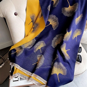 Detail showing double-sided cashmere scarf with ginkgo leaf pattern and elegant fringe