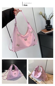Detail of pink hobo bag with silver butterfly charms and adjustable strap