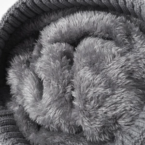 Thick dark grey fleece lining of a women's winter knit beanie showing soft texture
