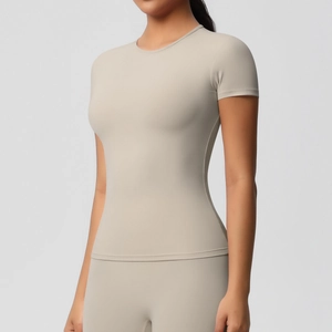 Gros plan d'un t-shirt de yoga beige slim montrant le tissu respirant et le col rond ajusté