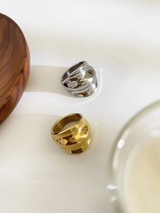 Detail view of wavy irregular wide rings in polished gold and silver finishes