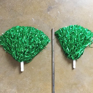 Detailweergave van twee groene cheerleader-poms met witte handvatten en een meetlint erbij