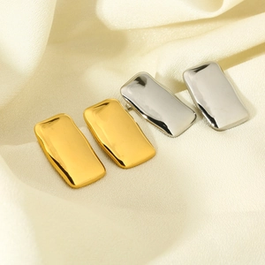 Detailed macro shot of wavy texture on gold and silver rectangle stainless steel earrings