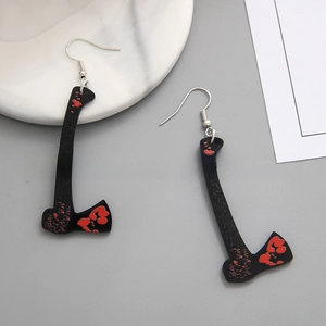 Detail of axe-shaped acrylic earrings with realistic red blood splatter for Halloween